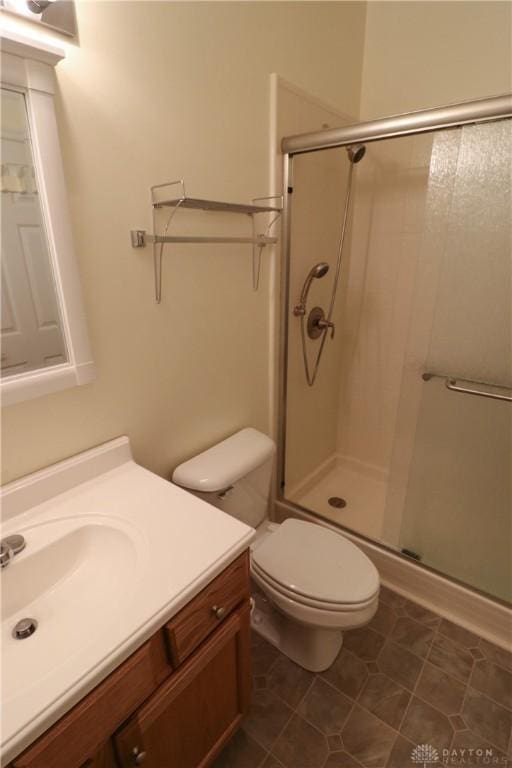 full bathroom with a stall shower, tile patterned flooring, vanity, and toilet