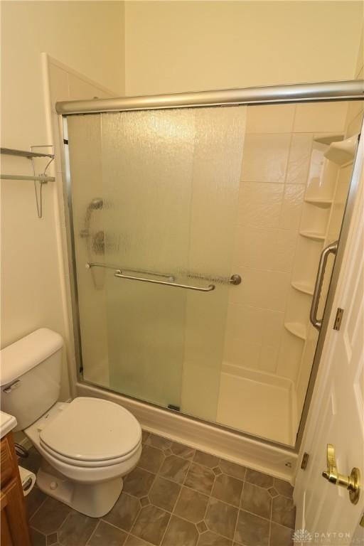 full bathroom featuring toilet, tile patterned floors, a shower stall, and vanity