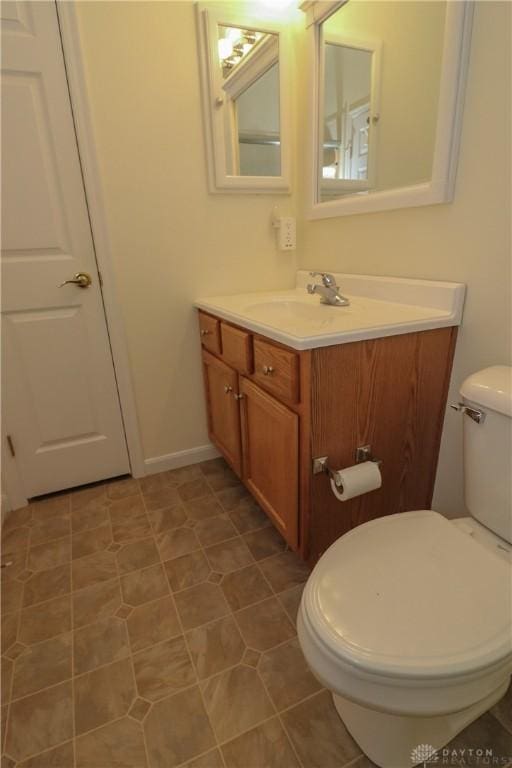 bathroom with tile patterned flooring, vanity, and toilet