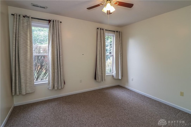 carpeted spare room with ceiling fan and a wealth of natural light