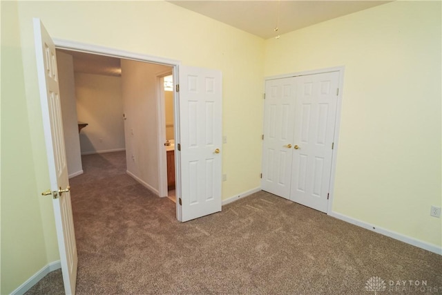 unfurnished bedroom with carpet floors, a closet, and baseboards