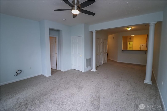 interior space featuring carpet floors, ornate columns, visible vents, a ceiling fan, and baseboards