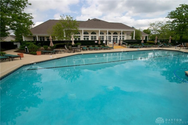 community pool featuring a patio and fence