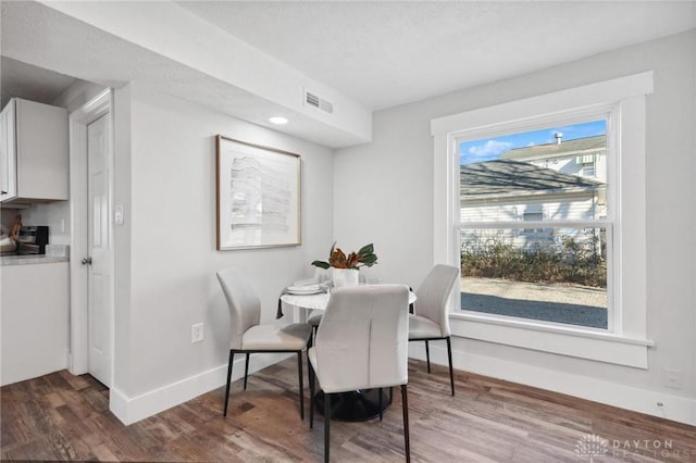 dining space with hardwood / wood-style floors and a textured ceiling