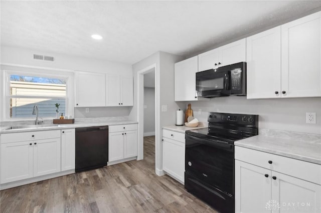 32 W Main St, Phillipsburg, OH 45354 - kitchen featuring black appliances, a sink, light wood-type flooring, white cabinetry, and recessed lighting