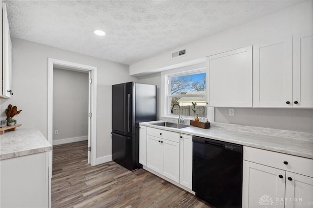 kitchen with white cabinetry, sink, hardwood / wood-style floors, a textured ceiling, and black appliances