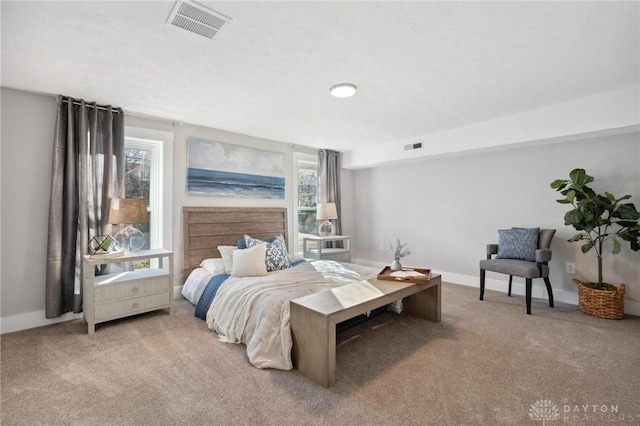 bedroom with light carpet and multiple windows