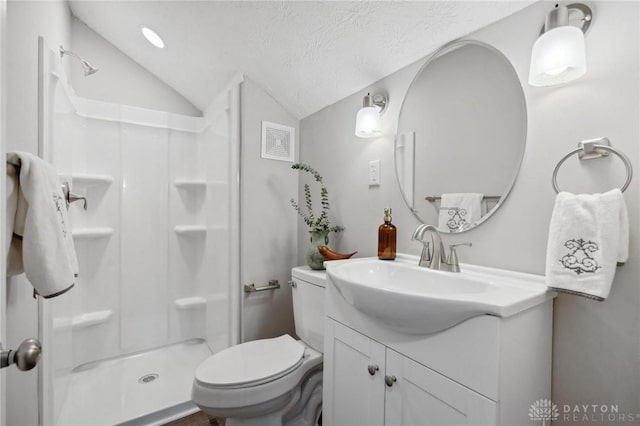 bathroom featuring vanity, a shower, vaulted ceiling, toilet, and a textured ceiling