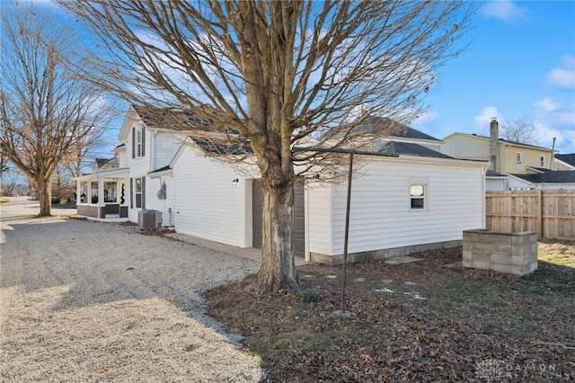 view of side of property with an outdoor living space and central air condition unit