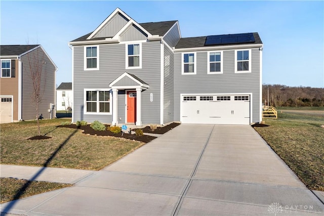 view of front facade featuring a garage, a front yard, and solar panels