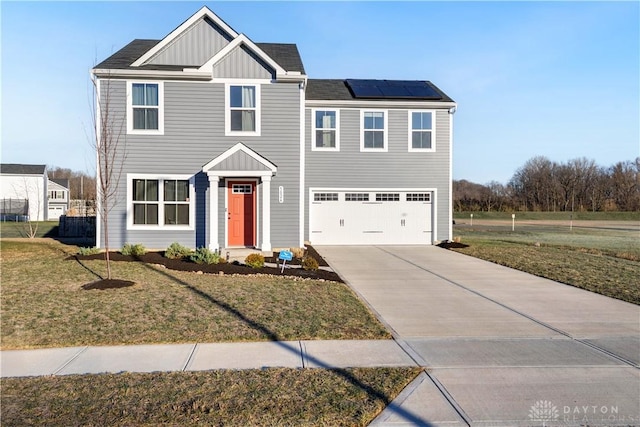 view of front of house featuring a front yard, solar panels, and a garage