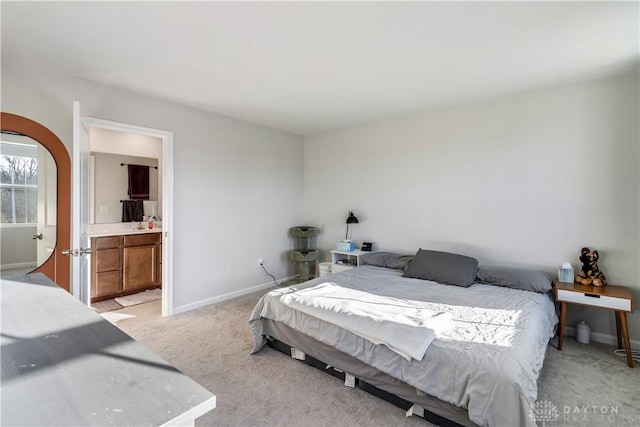 bedroom featuring light carpet and ensuite bath