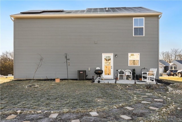 rear view of house with a patio area, central AC, and solar panels