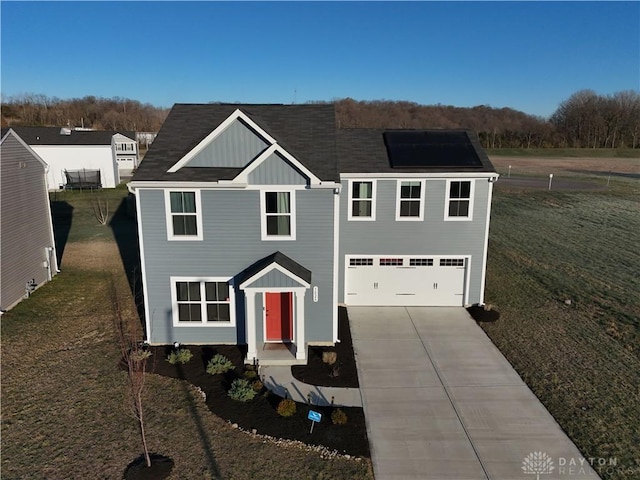 view of front of house with a garage, a front lawn, and solar panels