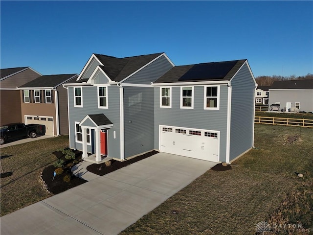 view of front of home featuring a front lawn, solar panels, and a garage