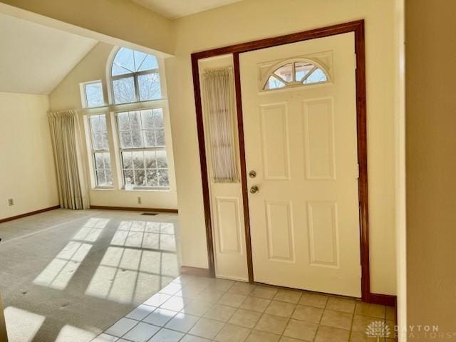 tiled foyer featuring vaulted ceiling