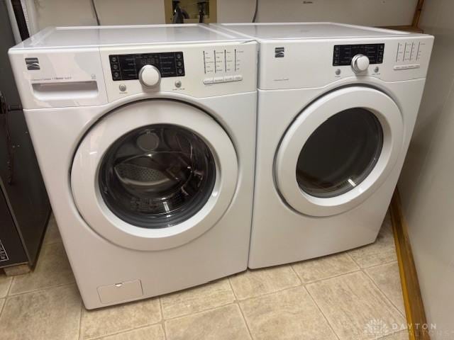 laundry room with washer and clothes dryer and light tile patterned floors