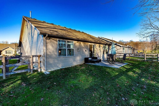 back of property with a yard and a patio