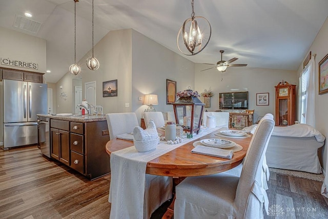 dining room featuring dark hardwood / wood-style floors, ceiling fan, sink, and vaulted ceiling