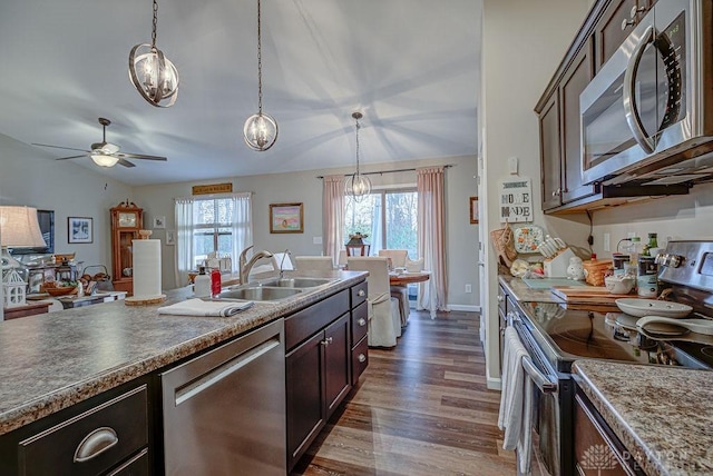 kitchen with stainless steel appliances, decorative light fixtures, sink, and dark brown cabinets