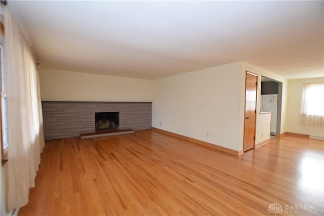 unfurnished living room featuring light wood-type flooring and a fireplace