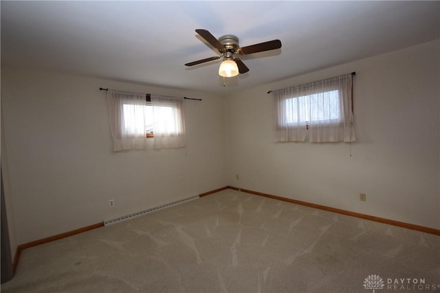 carpeted spare room with baseboard heating and ceiling fan