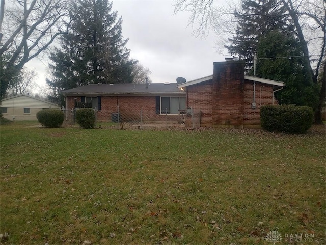 rear view of house featuring a lawn