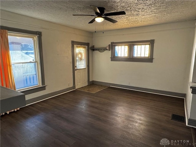 interior space with ceiling fan, dark hardwood / wood-style flooring, and a textured ceiling