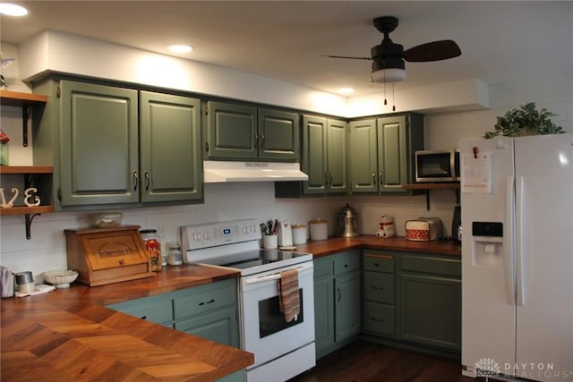 kitchen with under cabinet range hood, open shelves, wood counters, white appliances, and green cabinets