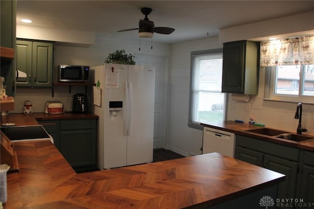 kitchen featuring wooden counters, green cabinets, white appliances, a ceiling fan, and a sink