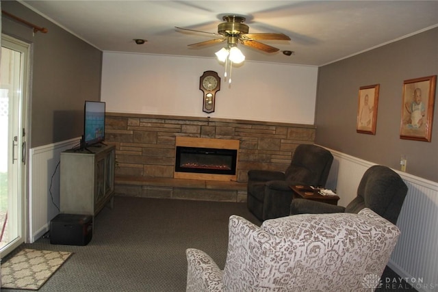 living room featuring a fireplace, ornamental molding, and wainscoting