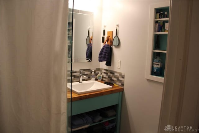 bathroom with tasteful backsplash and vanity