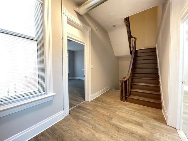 staircase with baseboards and wood finished floors