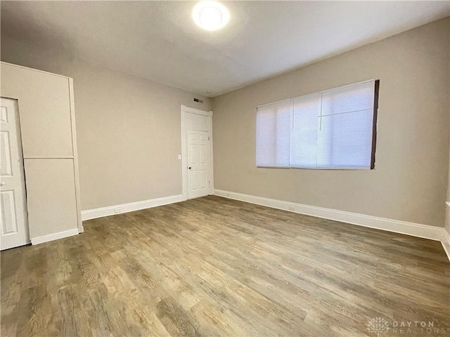 empty room with baseboards and wood finished floors