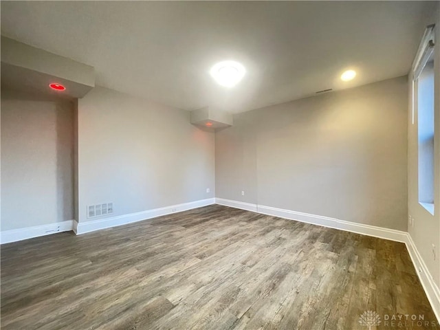 spare room featuring visible vents, baseboards, and wood finished floors