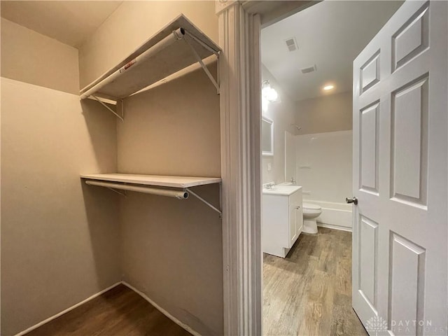 walk in closet with visible vents and wood finished floors