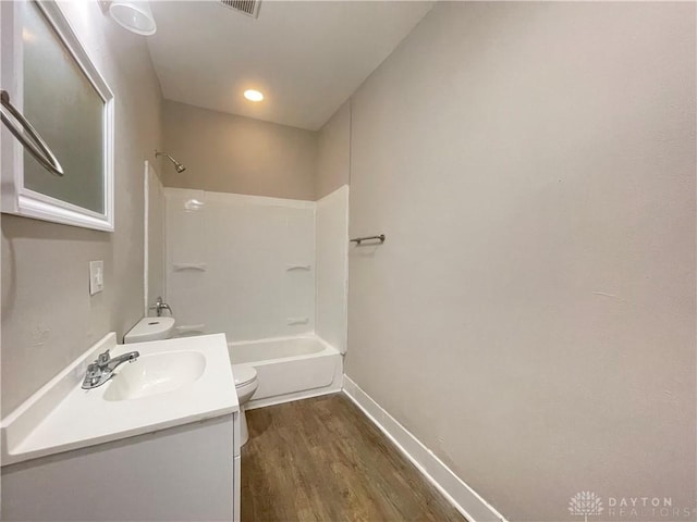 full bathroom featuring toilet, wood finished floors, shower / bath combination, baseboards, and vanity