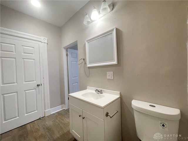 bathroom featuring vanity, toilet, and wood finished floors