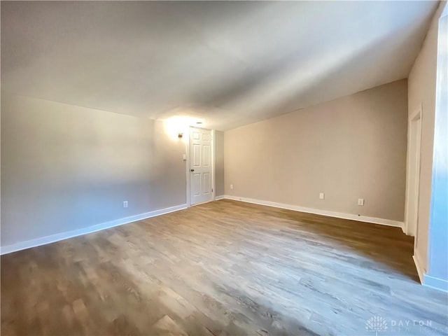 empty room with baseboards and wood finished floors