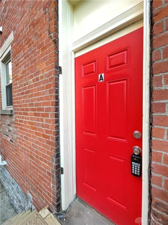 doorway to property featuring brick siding