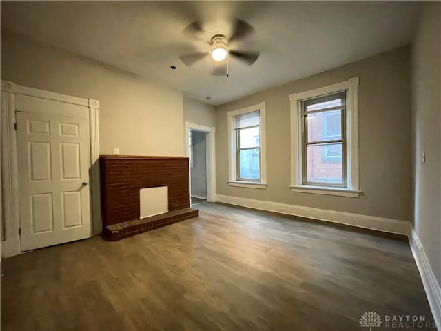 unfurnished living room featuring a ceiling fan, baseboards, and wood finished floors