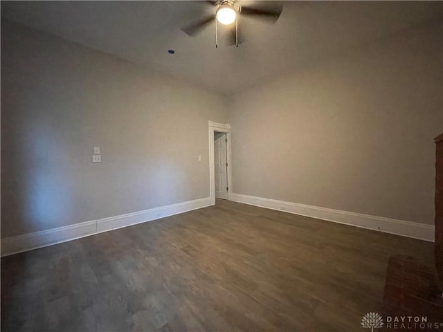 empty room featuring baseboards, dark wood-type flooring, and a ceiling fan