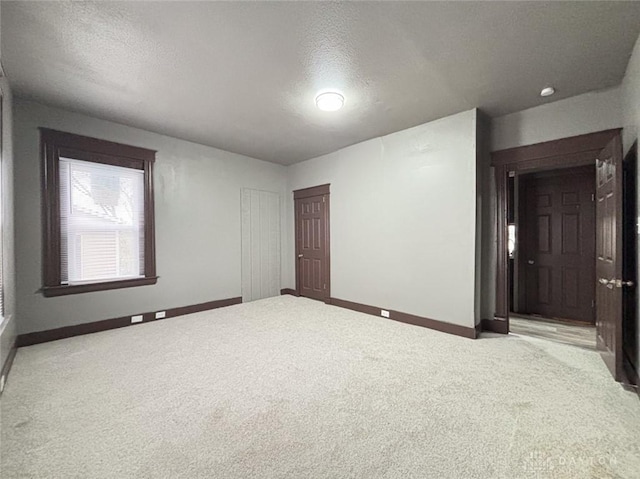 spare room with a textured ceiling and light colored carpet