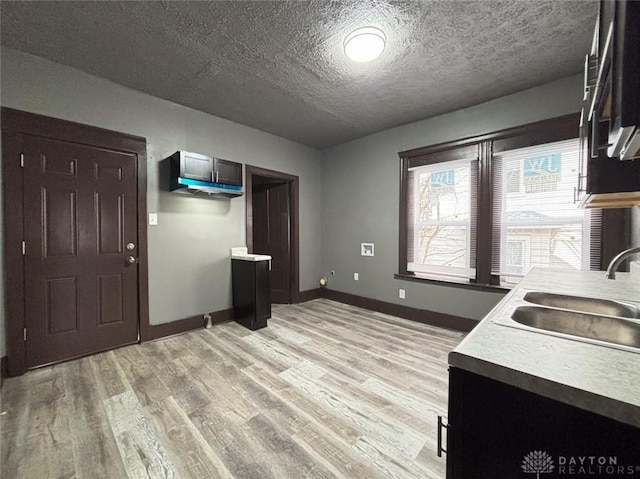 kitchen featuring a textured ceiling, light hardwood / wood-style flooring, and sink