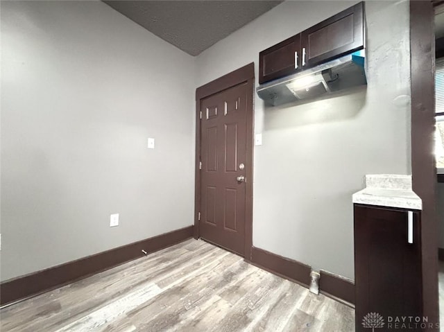 interior space with dark brown cabinets and light hardwood / wood-style floors