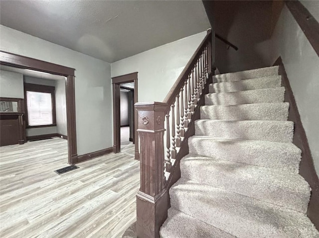 stairs featuring wood-type flooring