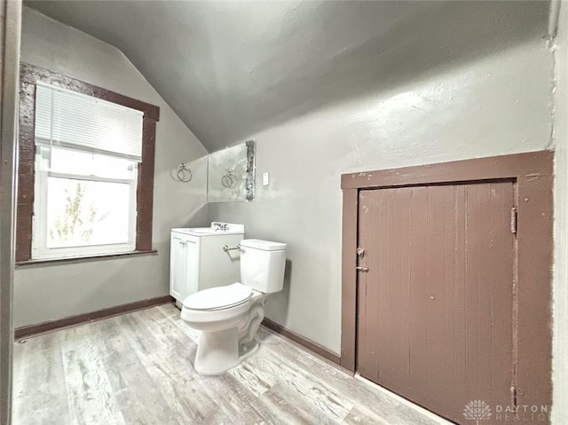 bathroom with sink, wood-type flooring, lofted ceiling, and toilet