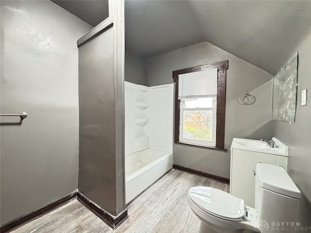 full bathroom featuring washtub / shower combination, hardwood / wood-style floors, lofted ceiling, toilet, and vanity