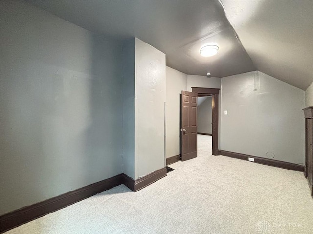 bonus room featuring light colored carpet and vaulted ceiling