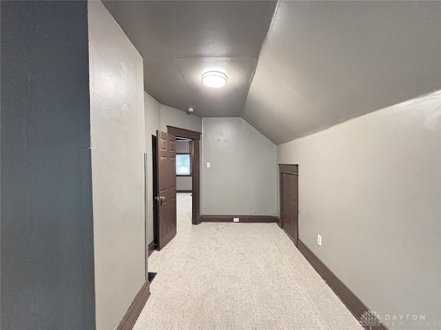 bonus room featuring light carpet and vaulted ceiling